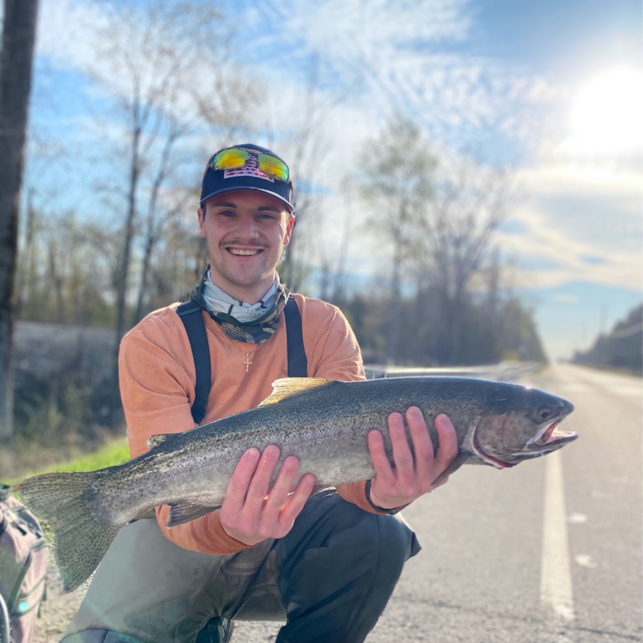Corey Tomsich smiling and holding a large fish.